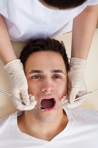 Человек проходит стоматологическое обследование в клинике — стоковое фото
