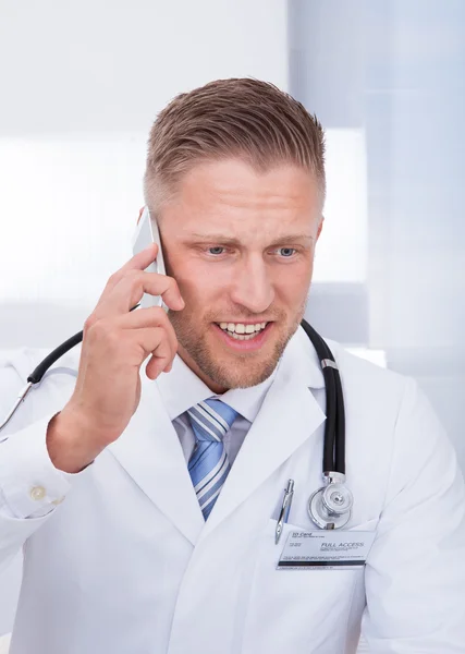Vänlig läkare chattar på sin mobiltelefon — Stockfoto