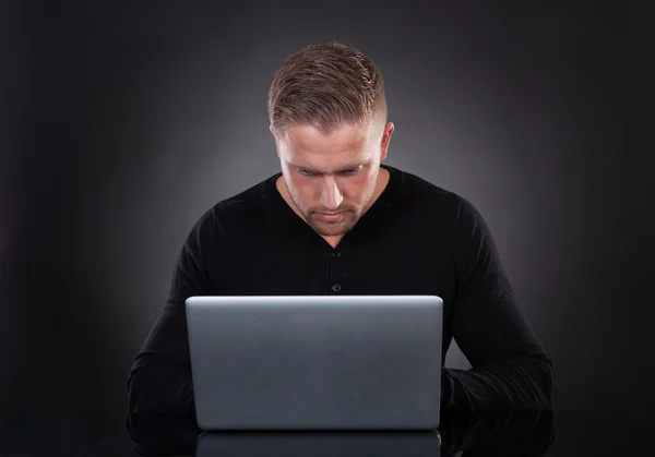 Man or hacker working on a laptop at night — Stock Photo, Image