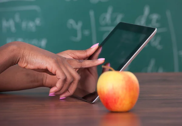 Profesor sosteniendo la tableta digital en el escritorio de la escuela — Foto de Stock