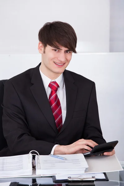 Businessman Calculating Finance Using Calculator At Desk — Stock Photo, Image