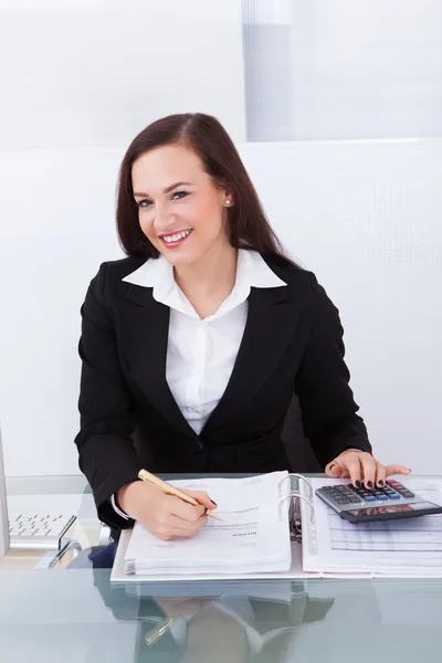 Happy Businesswoman Calculating Tax Royalty Free Stock Photos