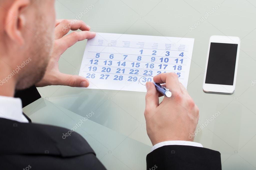 Businessman marking his dairy schedule checking for appointments