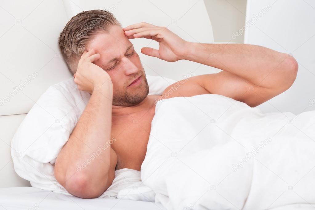 Man waking up with a nasty headache