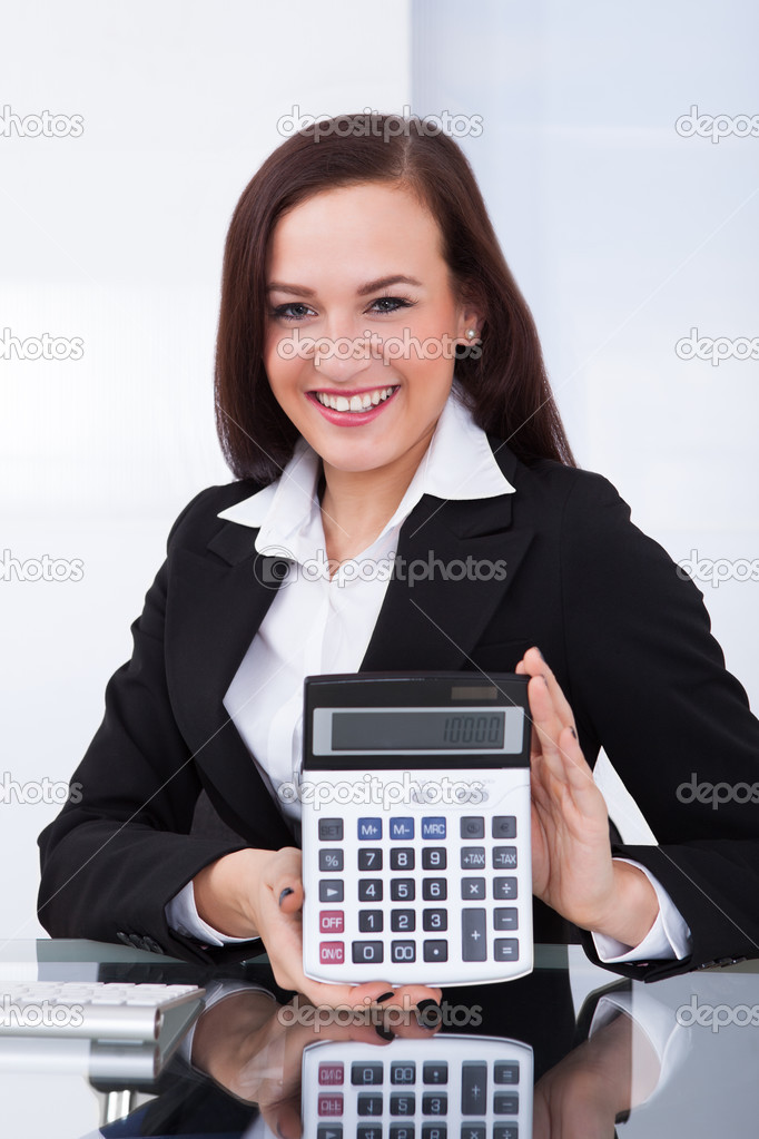 Businesswoman Holding Calculator At Desk