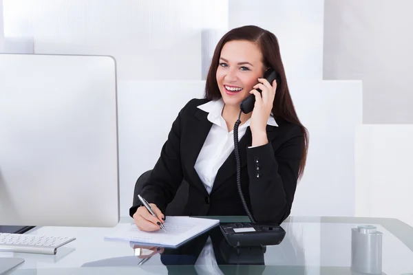 Empresaria usando teléfono en el escritorio —  Fotos de Stock