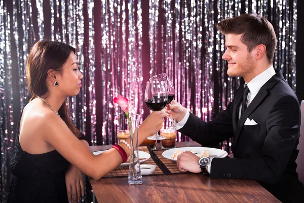 Casal torrefação de vinhos na mesa do restaurante — Fotografia de Stock