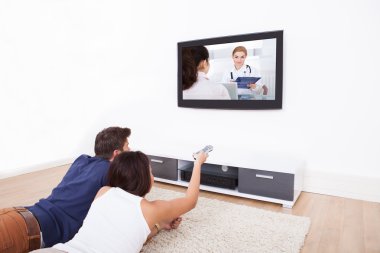 çift evde televizyon izliyor.