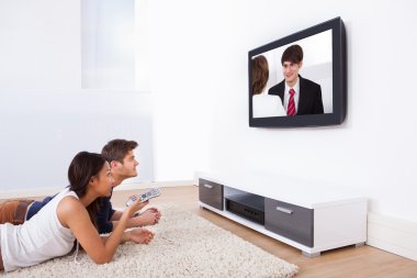 çift evde televizyon izliyor.