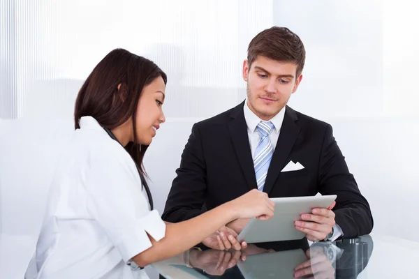 Docteur montrant la tablette numérique à l'homme d'affaires — Photo