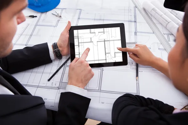 Arquitetos com tablet digital trabalhando em Blueprint — Fotografia de Stock