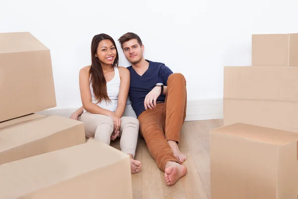 Casal sentado no chão na nova casa — Fotografia de Stock