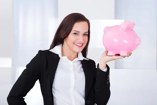 Empresária segurando banco porquinho — Fotografia de Stock