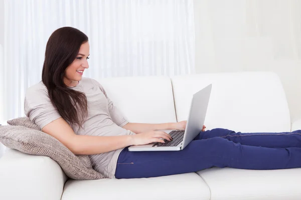 Vrouw met behulp van laptop thuis — Stockfoto