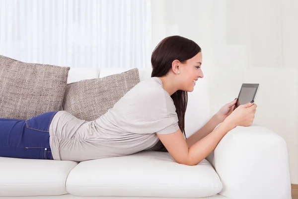 Mujer usando tableta digital en sofá —  Fotos de Stock