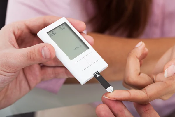 Doktor hastanın parmağına şeker ölçüm kullanarak — Stok fotoğraf