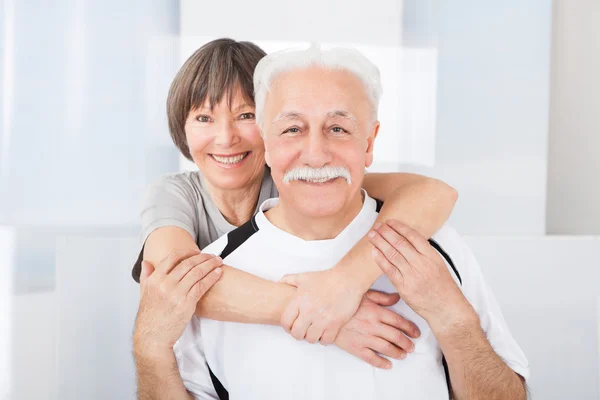 Seniorenpaar umarmt sich im Fitnessstudio — Stockfoto