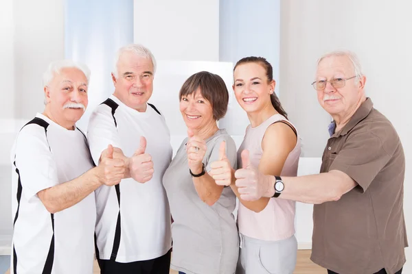 Gente confiada mostrando pulgares en el Healthclub — Foto de Stock