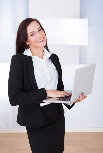 Donna d'affari ben vestita che utilizza il computer portatile in ufficio — Foto Stock