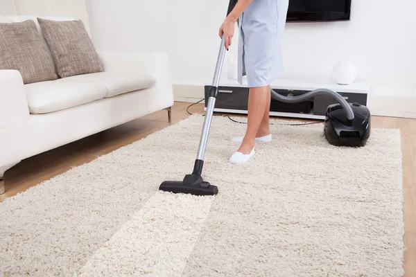 Meid schoonmaak tapijt met stofzuiger — Stockfoto