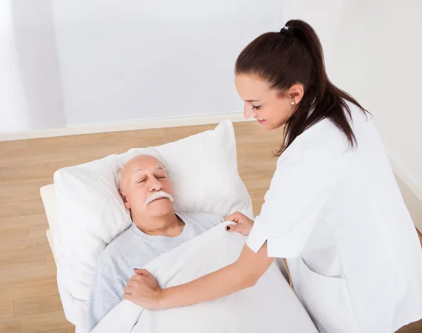 Doktor pokrývající starší muž s deka — Stock fotografie