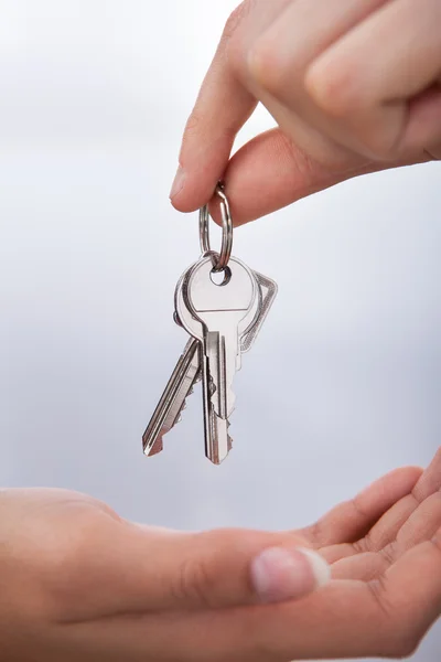 Main de l'agent donnant de nouvelles clés de maison à la femme — Photo