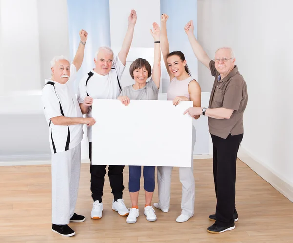 Mensen die leeg reclamebord op sportschool — Stockfoto