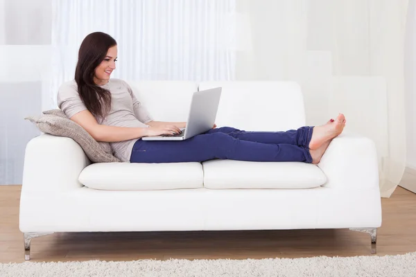 Vrouw met behulp van laptop thuis — Stockfoto