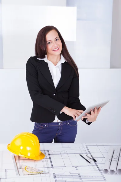 Arquiteto com tablet digital em pé na mesa — Fotografia de Stock