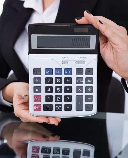 Calculadora de retención de mujer de negocios en el escritorio — Foto de Stock