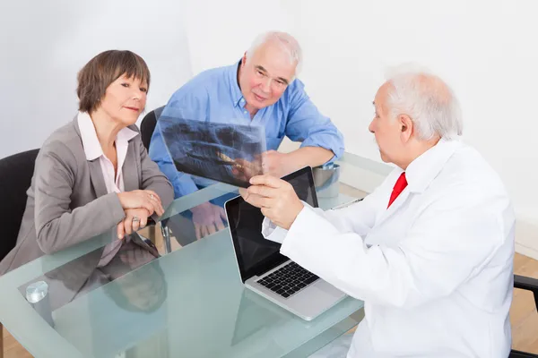 Zahnarzt erklärt Senioren-Paar das Röntgen — Stockfoto