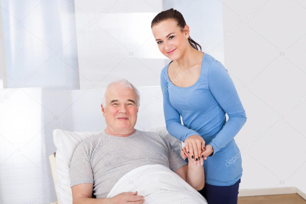 Portrait Of Caregiver Comforting Senior Man