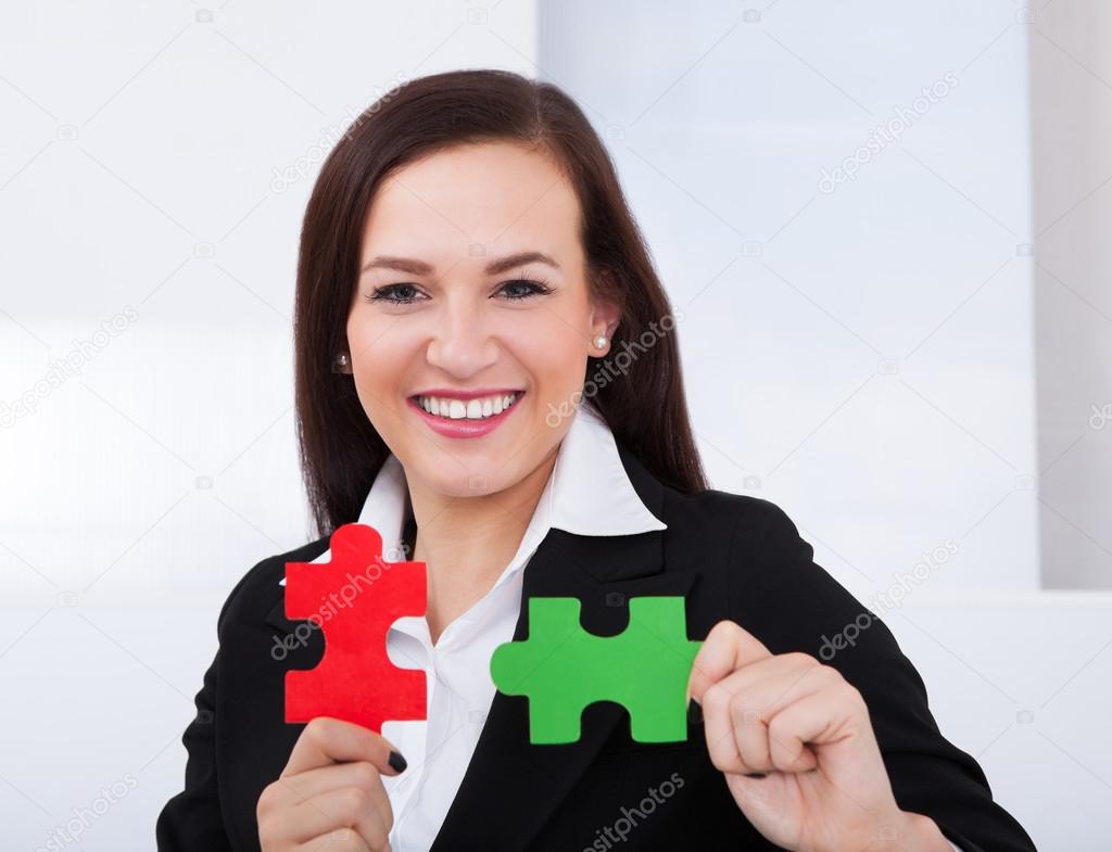 Happy Businesswoman Holding Puzzle Pieces