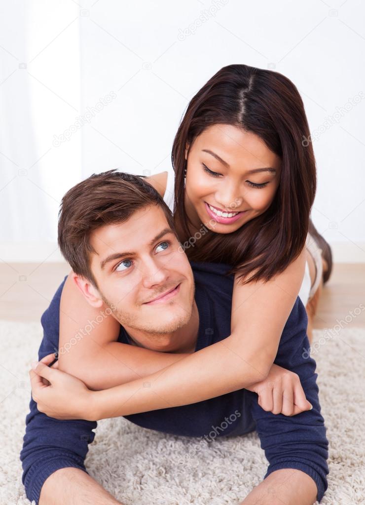 Portrait Of Loving Couple Lying On Rug