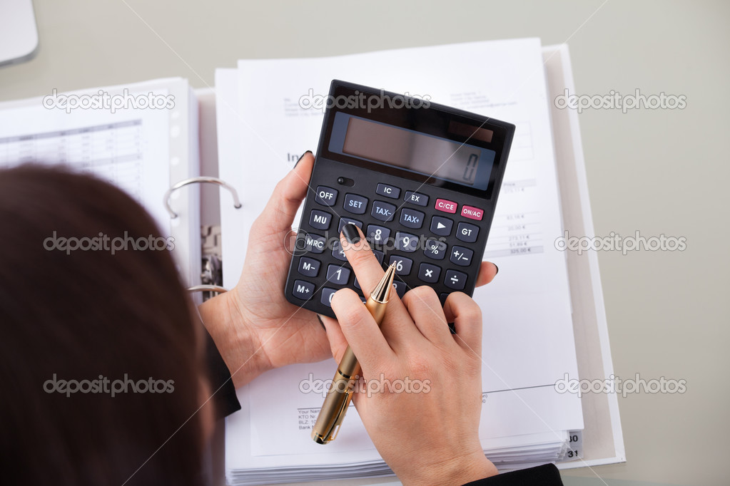 Accountant Calculating Tax At Desk