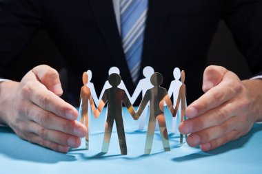 işadamı kağıt kişilik masa üzerinde koruma ekip eller