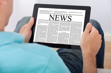 Dijital tablet gazete okuyan adam