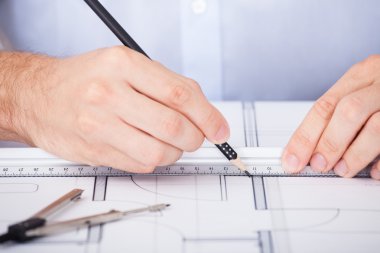 planı üzerinde çalışan mimar Resim kırpılmış