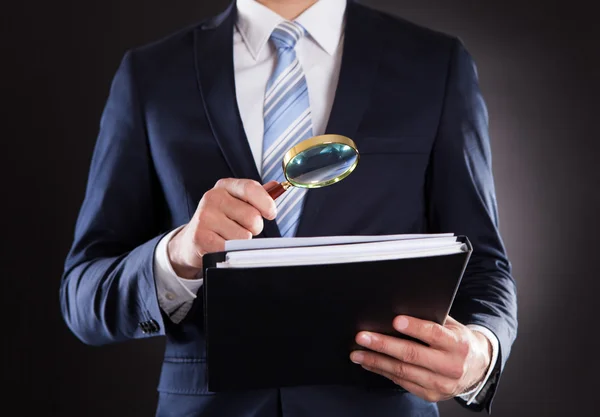 Businessman Examining Documents With Magnifying Glass — Stock Photo, Image