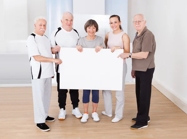 Lidé drží prázdné billboard v tělocvičně — Stock fotografie