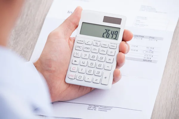 Businessman's Hands Calculating Invoice At Desk — Stock Photo, Image