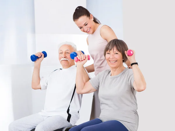 Trainer helpen senior koppel met halters — Stockfoto