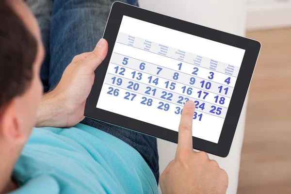 Homme utilisant le calendrier sur tablette numérique — Photo