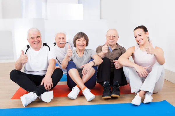 Trainerin mit Seniorinnen im Fitnessstudio — Stockfoto