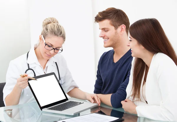 Doctor Showing Report To Couple On Laptop — Stock Photo, Image