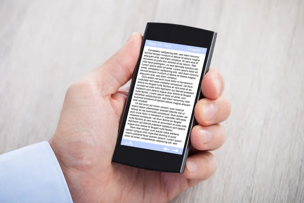 Mão do empresário exibindo eBook em Smartphone — Fotografia de Stock
