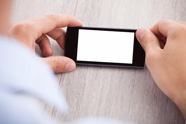 Geschäftsmann hält Smartphone mit leerem Bildschirm in der Hand — Stockfoto