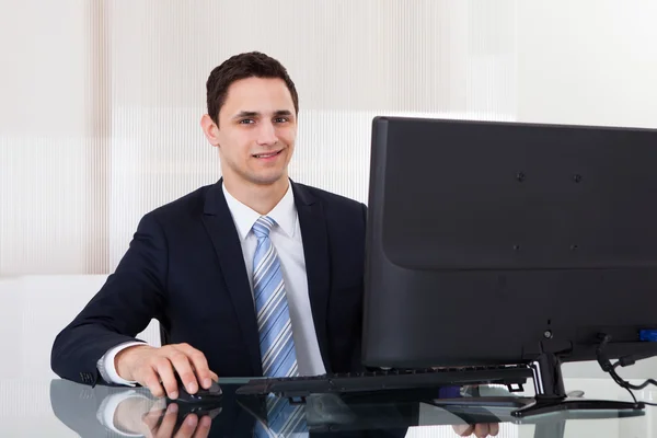 Joven hombre de negocios usando computadora en el escritorio de la oficina —  Fotos de Stock