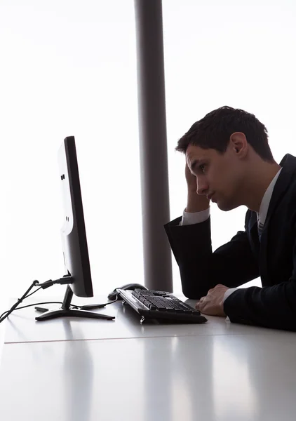 Беспокойный бизнесмен, глядя на компьютер в офисе — стоковое фото