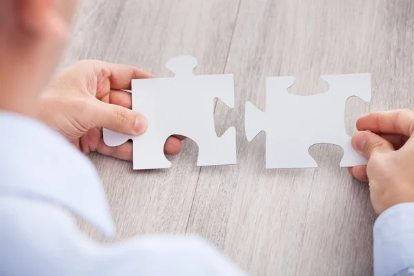Cropped Image Of Businessman Joining Jigsaw Pieces — Stock Photo, Image